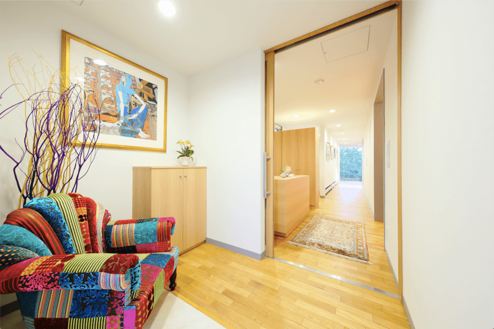 重厚な玄関開けると長い廊下の先にテラスの一面ガラスが見えます。
