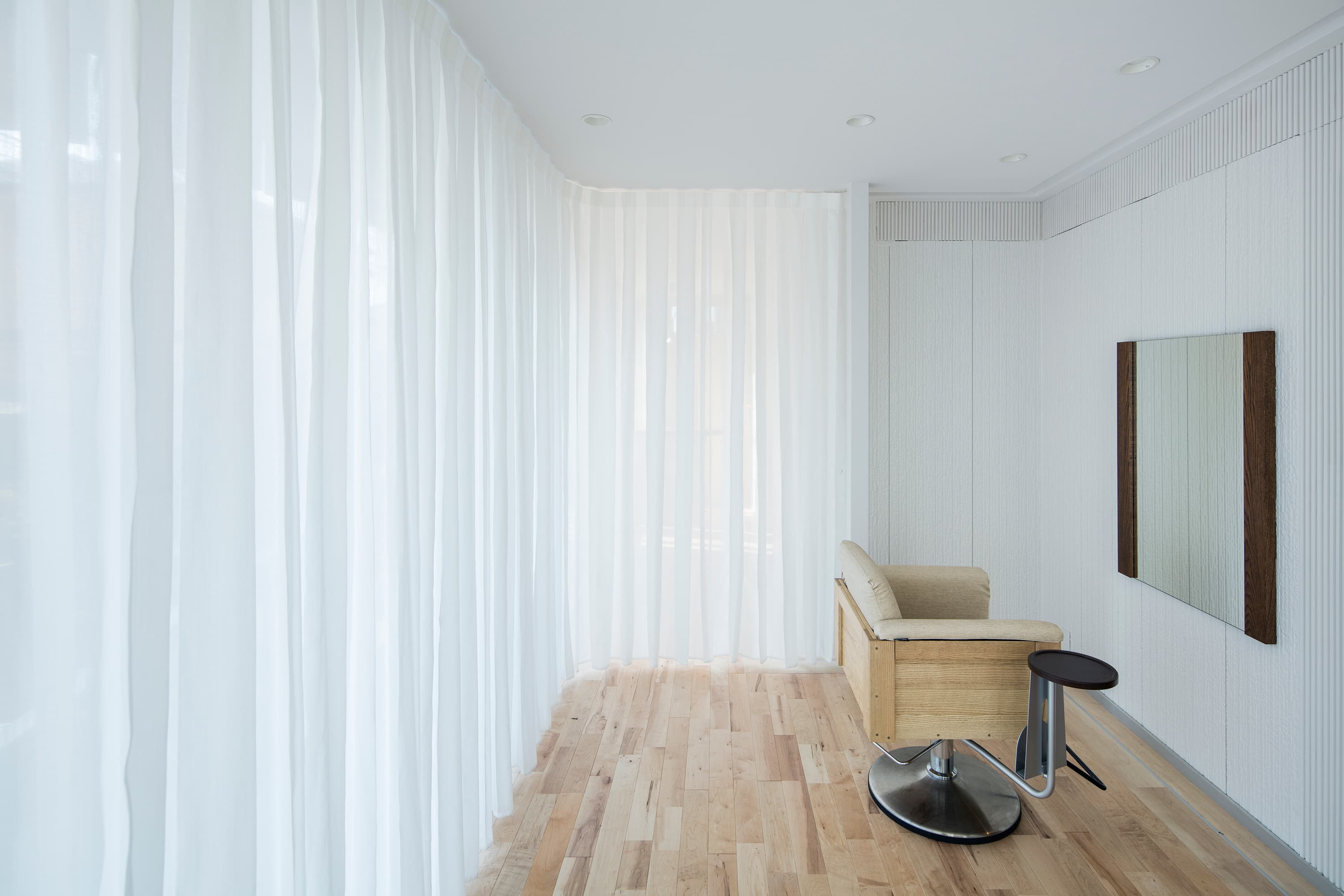 カーテン越しに光が差し込み、白を基調にしたスッキリ空間