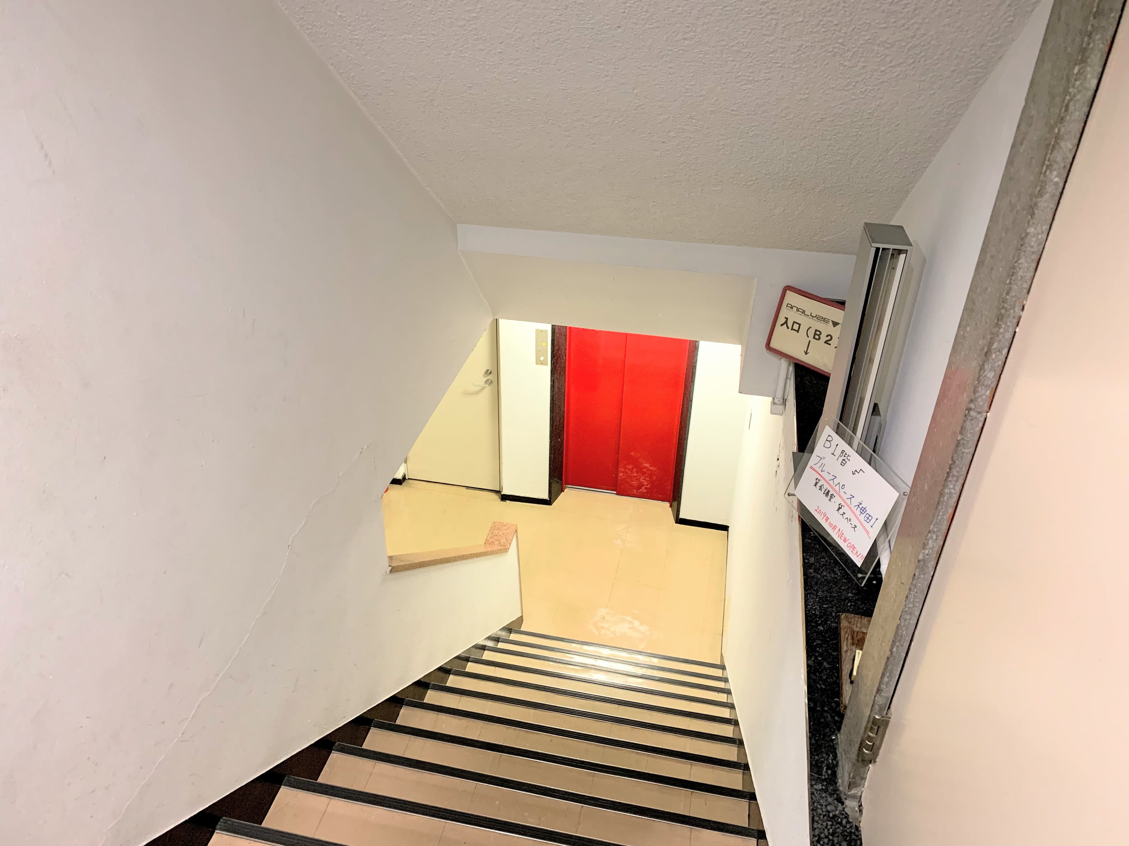 光起ビル1F階段 エレベーターの左のドアが当スペースです。