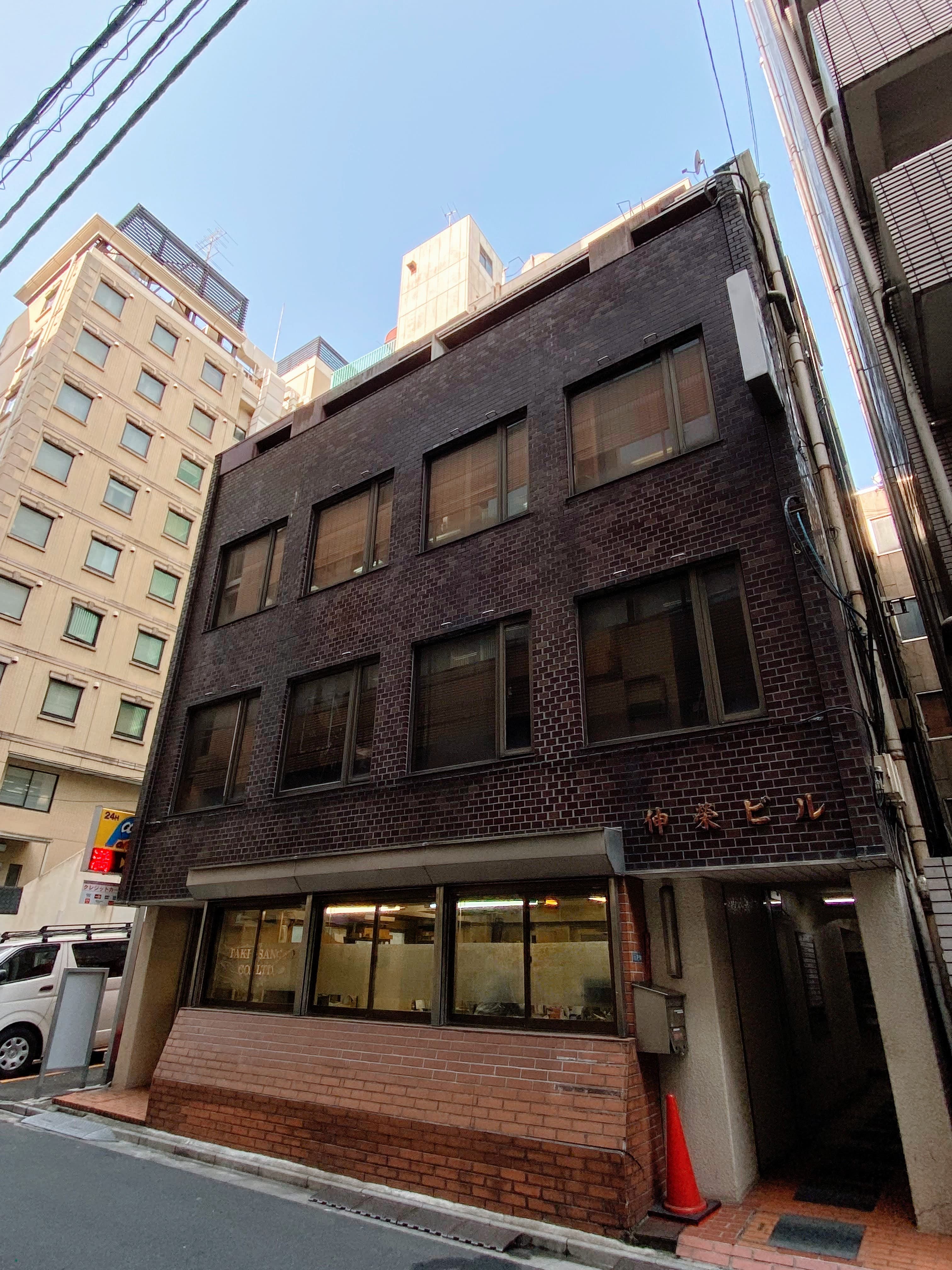 茶色のビルで隣に駐車場があります。