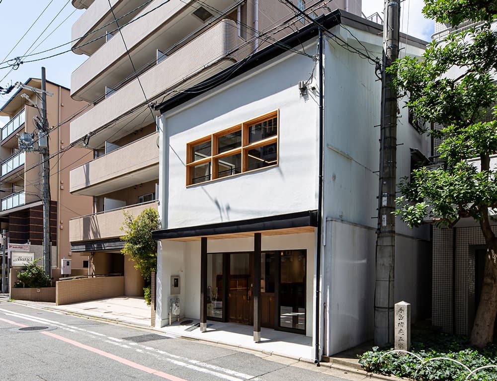 富小路三条にあるハチミツ屋さんから直進50m右手(西側)に"doué / どうえ"はあり、駐輪場やコインパーキング、コンビニなど