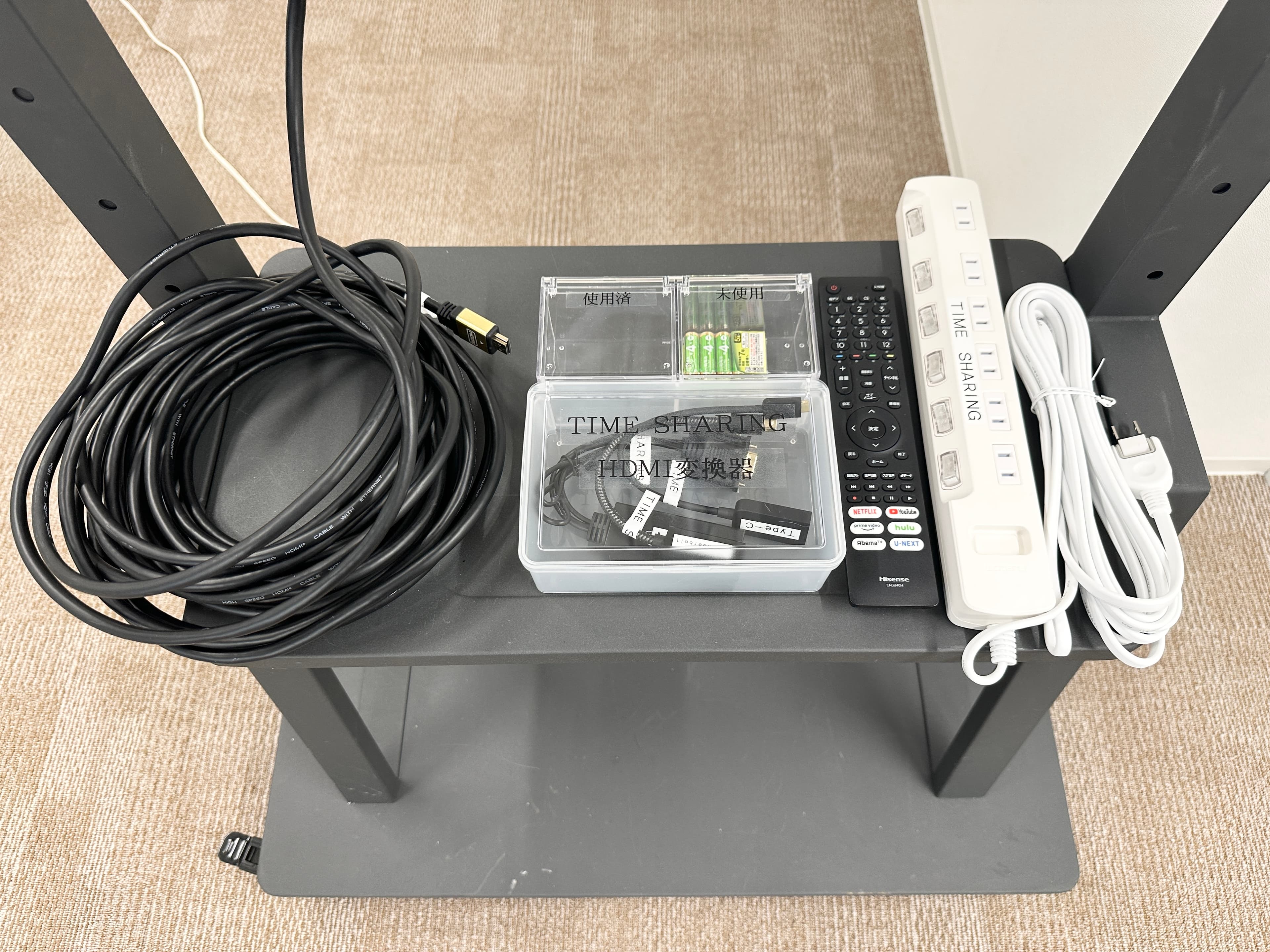 【モニター台に、変換機や延長コードなどの細かい備品を置いています】