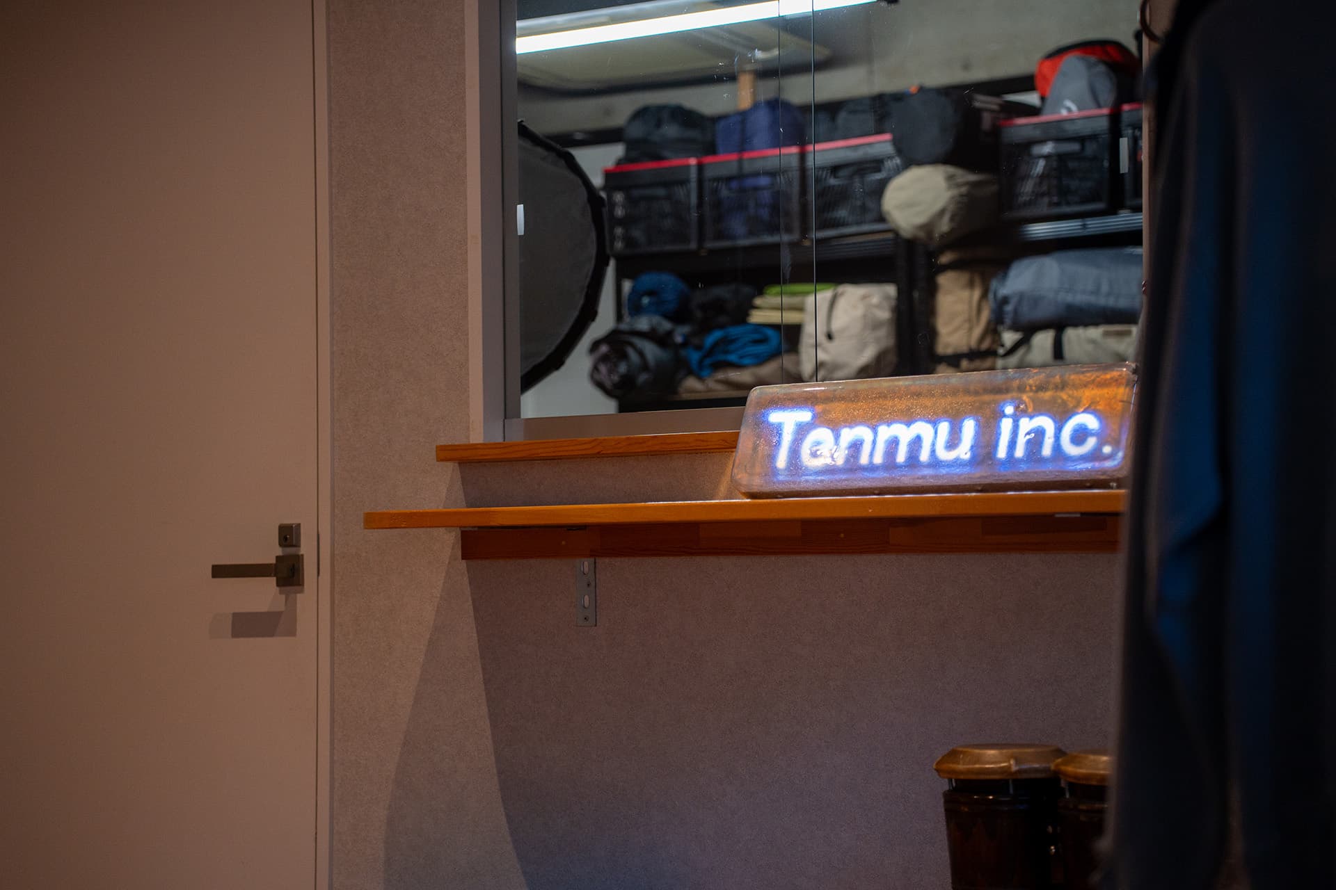入口すぐの受付カウンター。「Tenmu inc.」のネオンサインがお出迎えします。