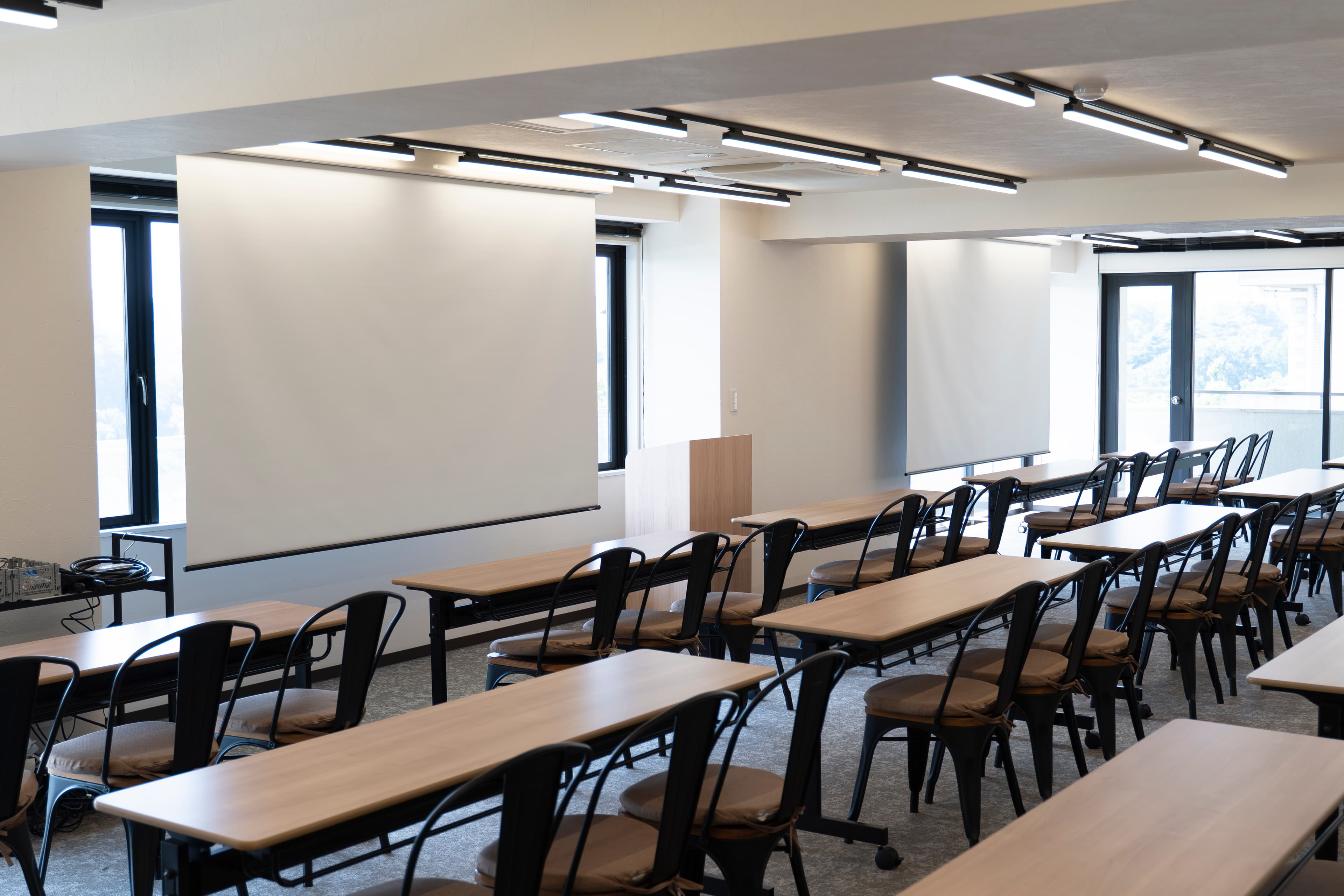 【大きな120インチスクリーン2枚にプロジェクターから同時投影できるので、どの席からも映像が見やすくなっています】