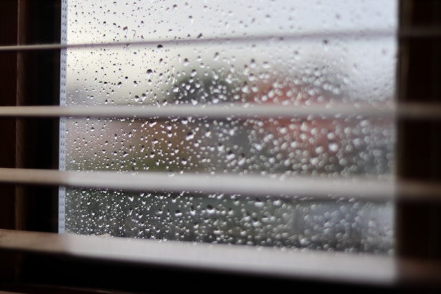 窓に雨粒が残る雨の日の室内