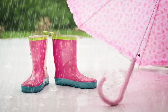 雨の中に置かれた子どもの長靴と傘