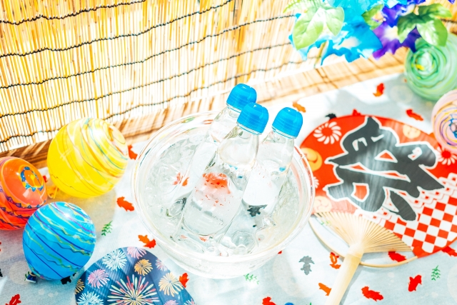 冷えたラムネやヨーヨーが飾られた夏のイベント会場