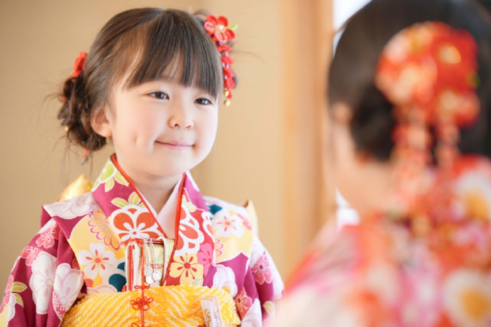 鏡を見て微笑む和装姿の女の子