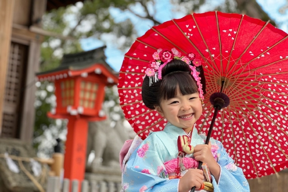 和傘をさしてポーズをとる七五三の女の子